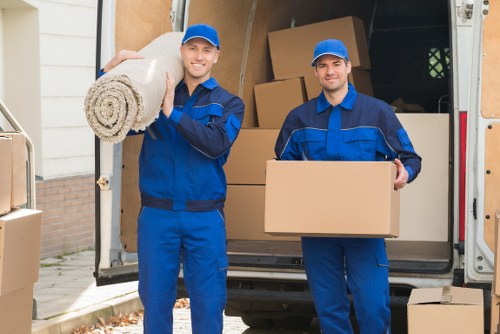 Professional movers carrying packed boxes during a local house move